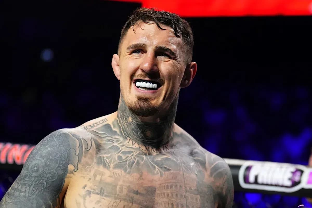 Boxer smiling with tattoos and mouthguard in ring