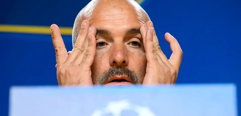 Manager at press conference touching face and forehead