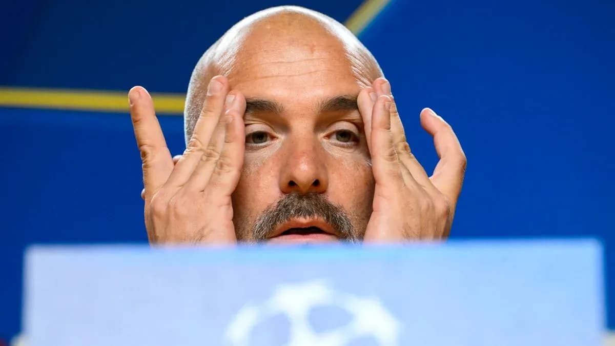 Manager at press conference touching face and forehead