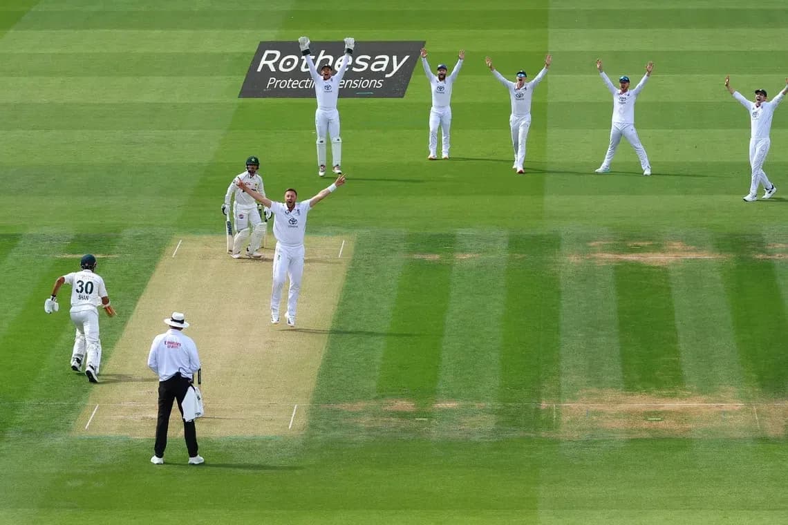 Bowler celebrating appeal with teammates during cricket match