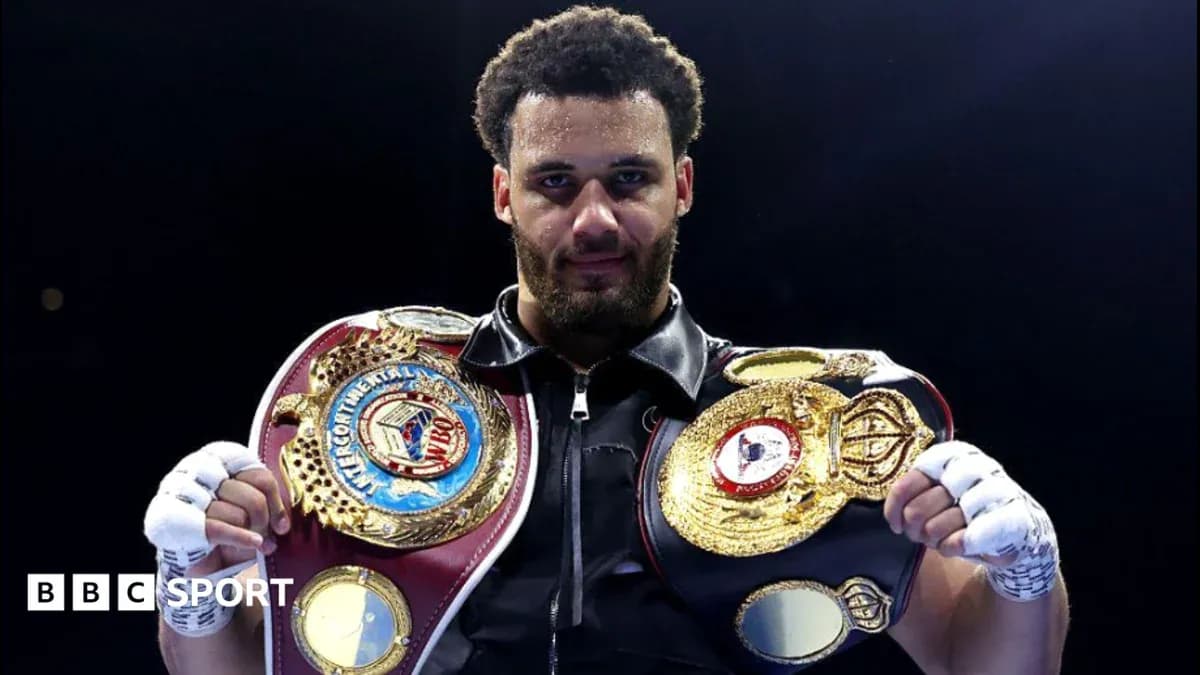 Boxer holding championship belts in the ring