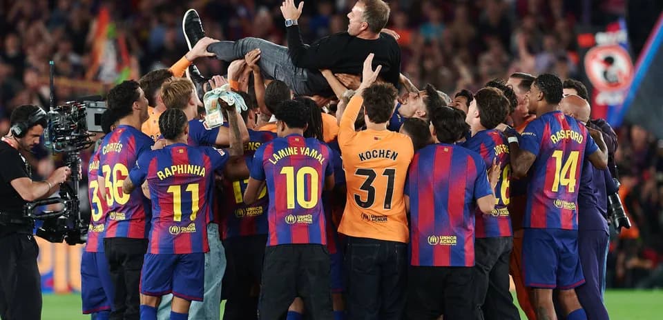 Barcelona players celebrating and lifting coach in joy
