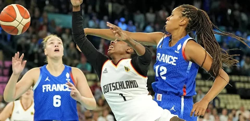 Players competing for the ball during basketball match