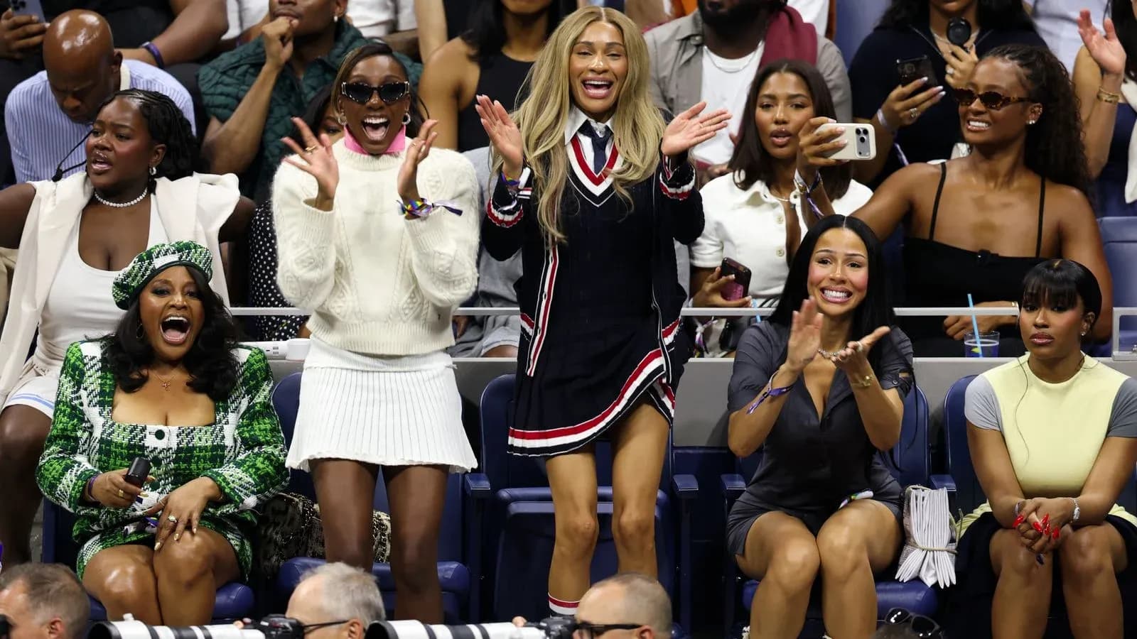Fans cheering in the stands at a tennis match