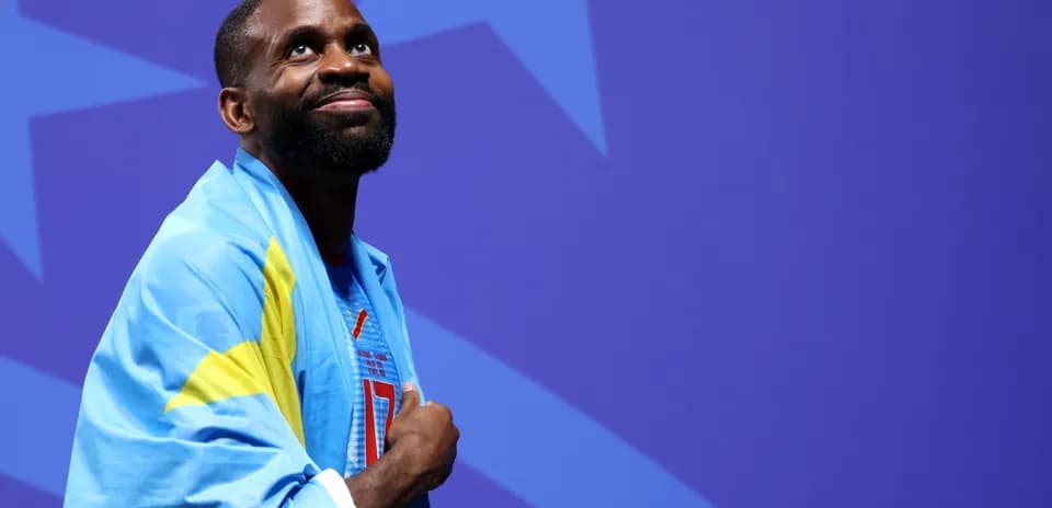 Athlete wearing a blue flag, looking upward