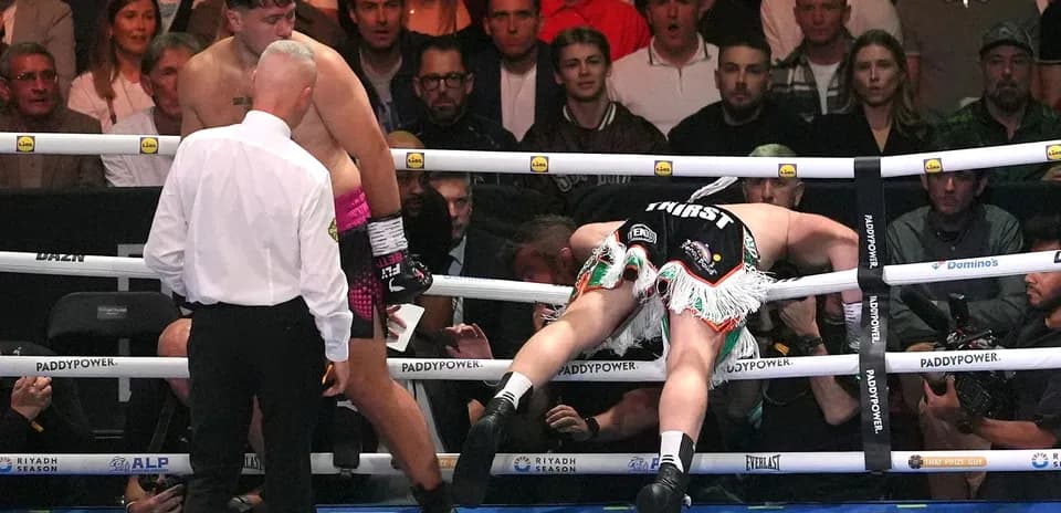 Boxer falling through the ropes during a match