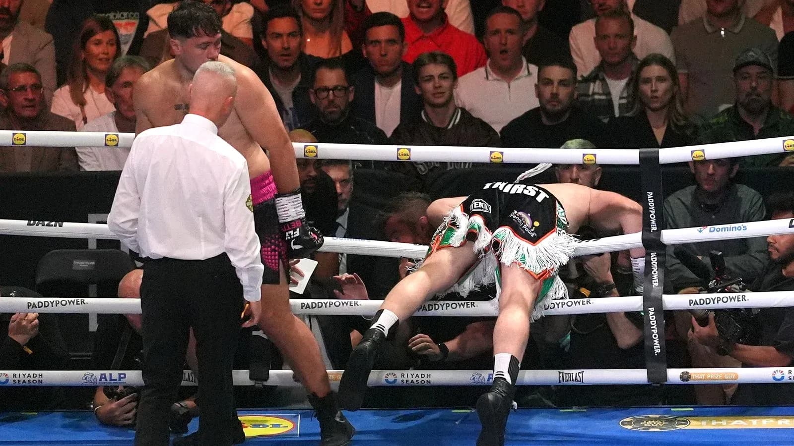 Boxer falling through the ropes during a match