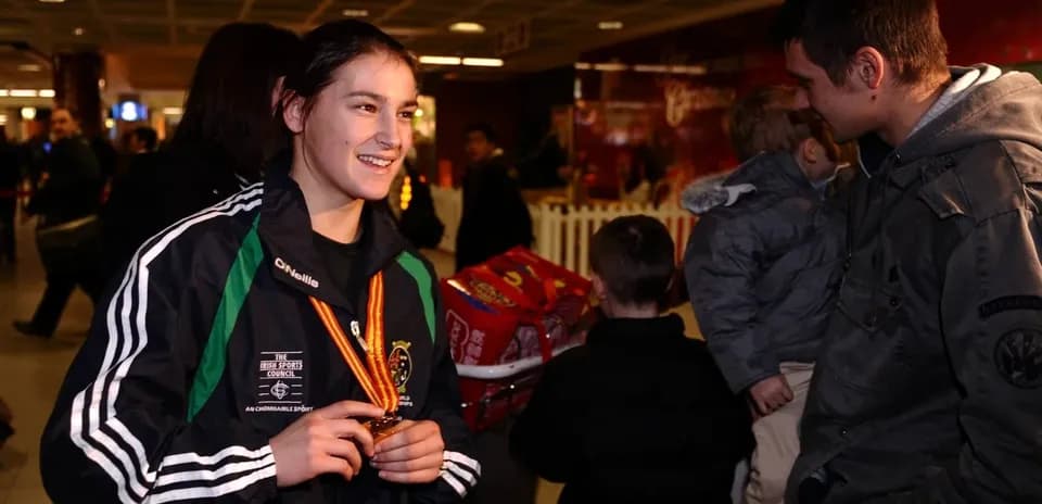 Athlete displaying medal at airport arrival