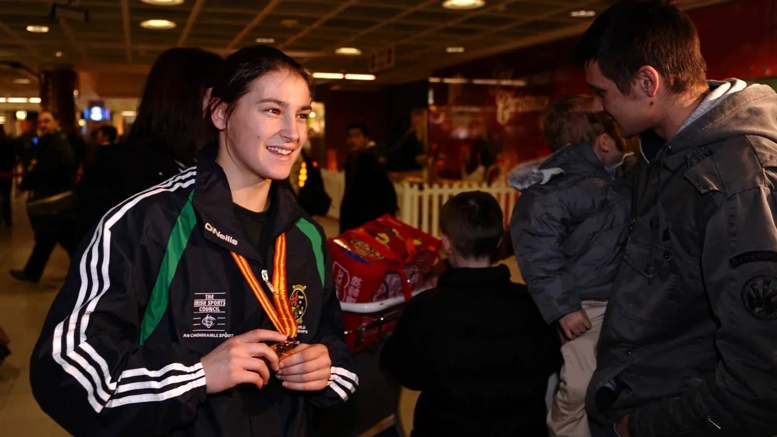 Athlete displaying medal at airport arrival