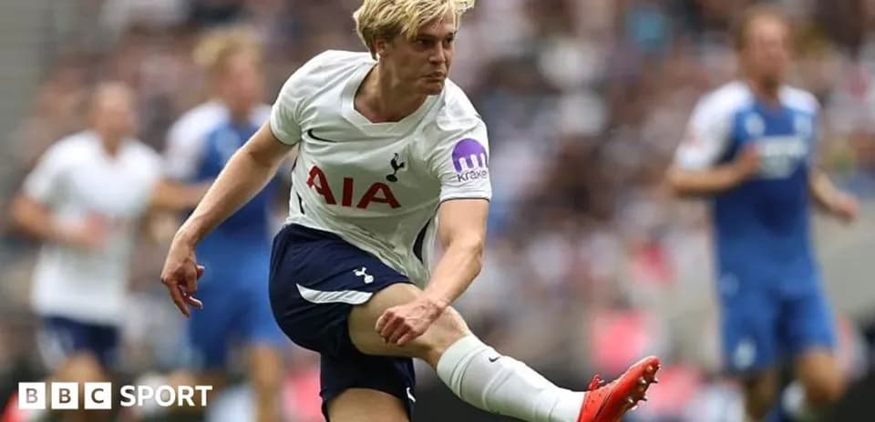 Tottenham player kicking ball during match action