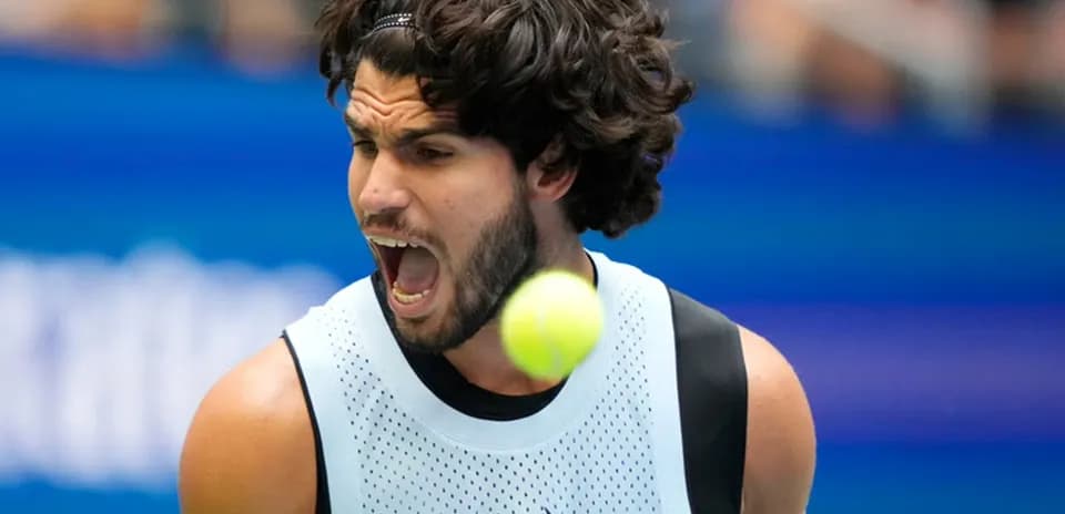Tennis player celebrating with ball in motion