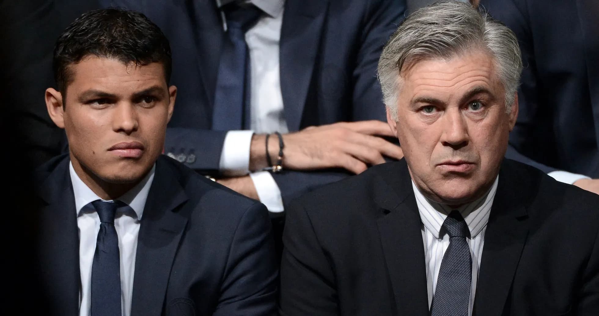 Two men in suits sitting closely together