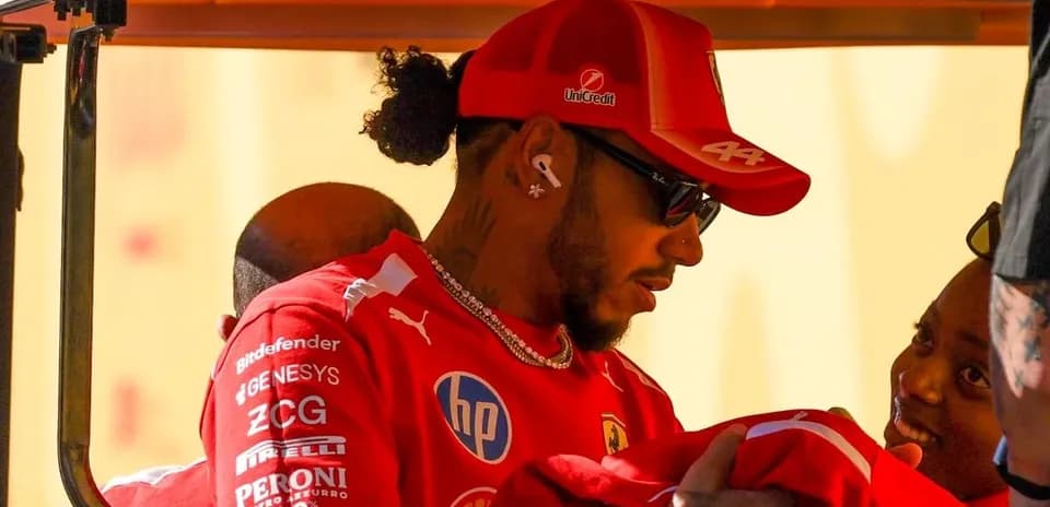 Driver wearing Ferrari gear interacting with a child