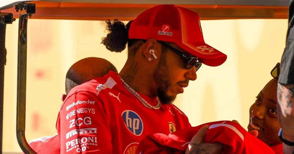 Driver wearing Ferrari gear interacting with a child