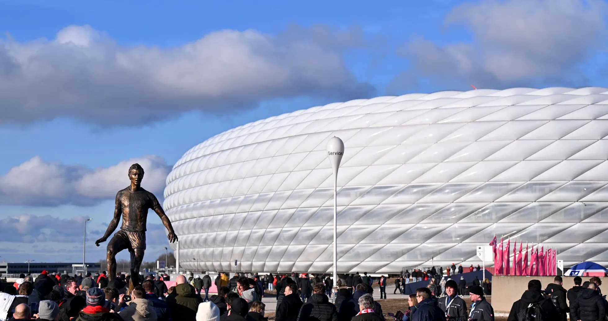 Fans gathering near stadium and statue before match