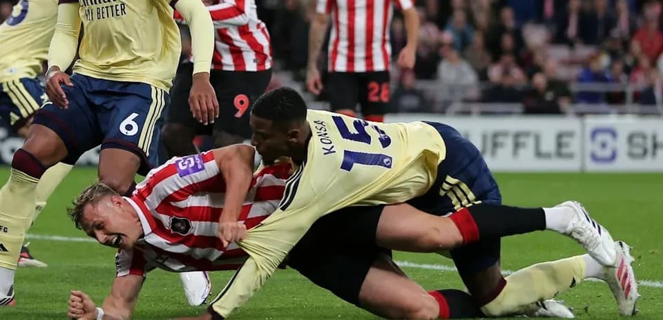 Players in a tackle during a football match