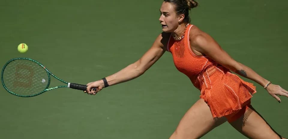 Tennis player reaching for a ball during match