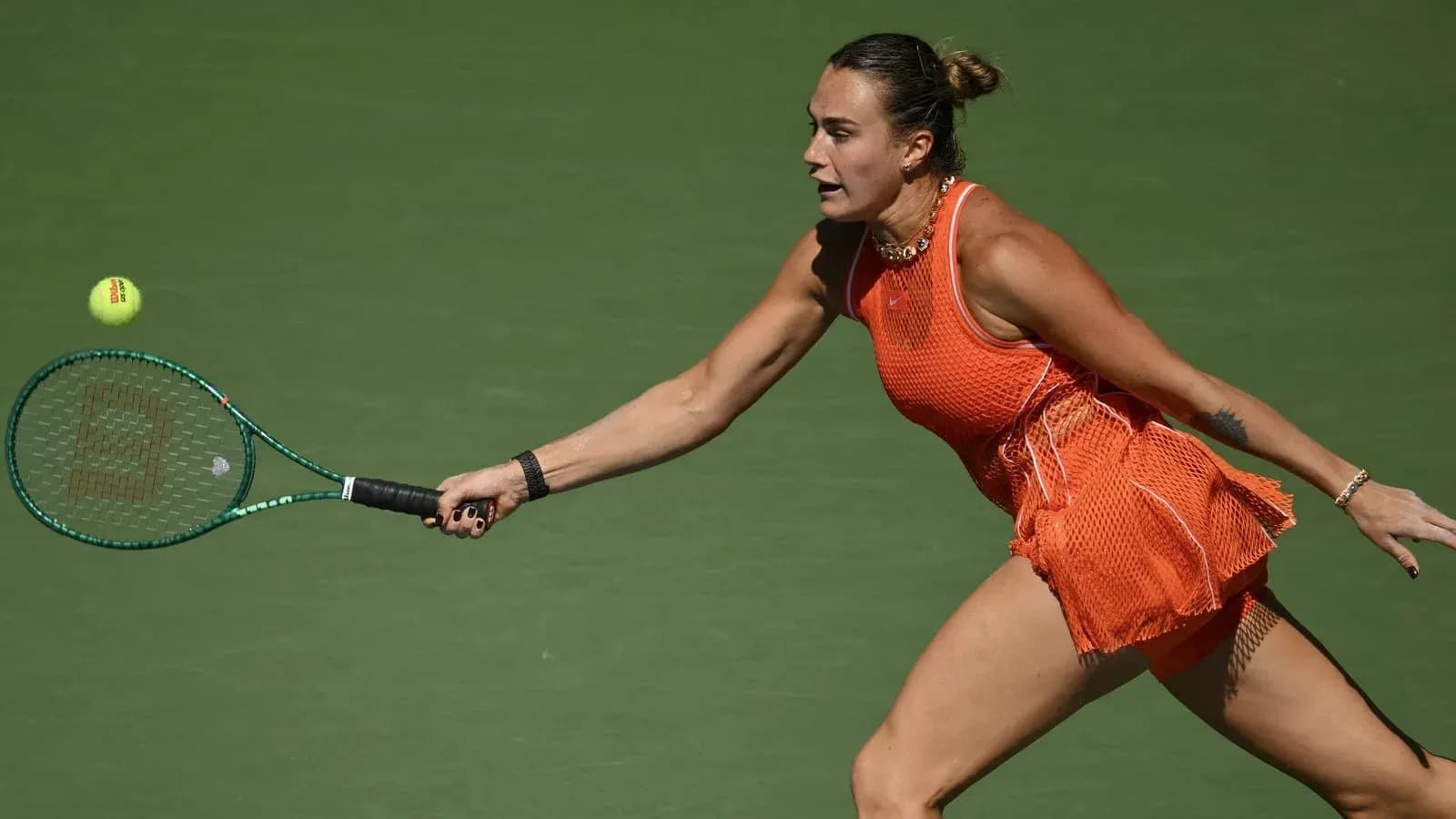 Tennis player reaching for a ball during match