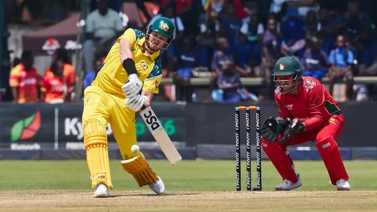Batsman hitting ball while wicketkeeper crouches