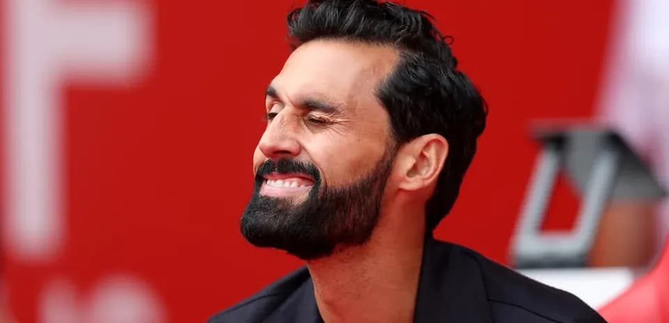 Man with beard smiling while sitting on bench