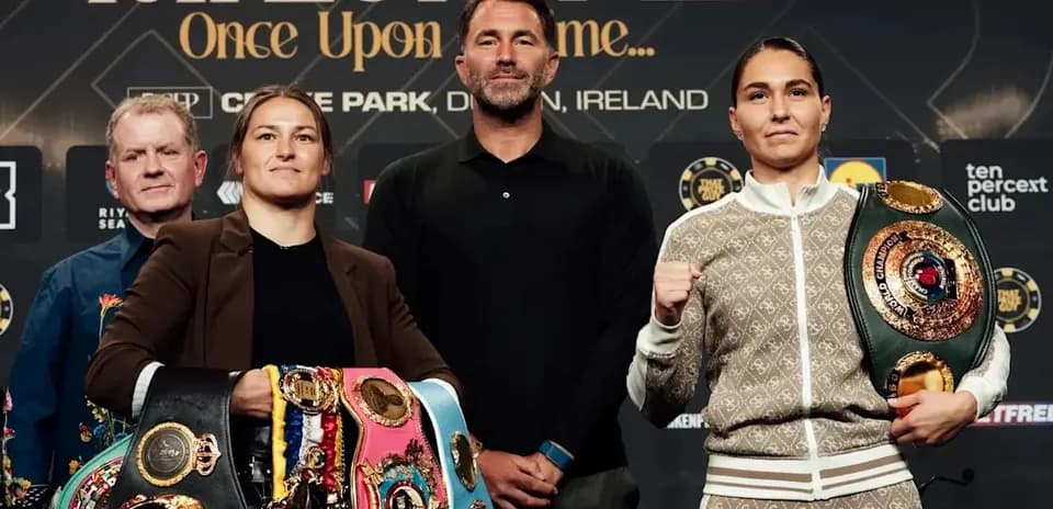 Two female boxers posing with championship belts at press event