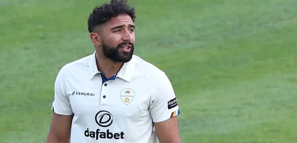 Cricketer in white kit during match on field
