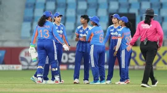Indian women's cricket team discussing strategy on field
