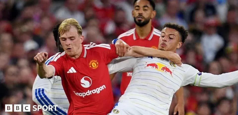 Two players grappling for the ball during match