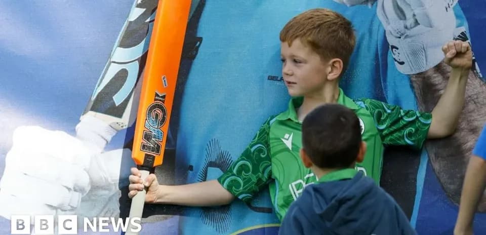 Child posing with cricket bat against mural backdrop