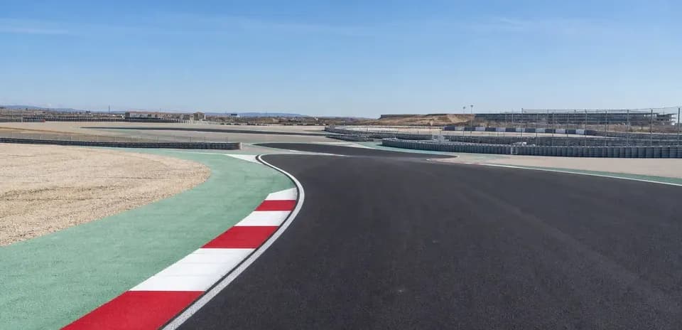 Curved racetrack with colored curbing and stands