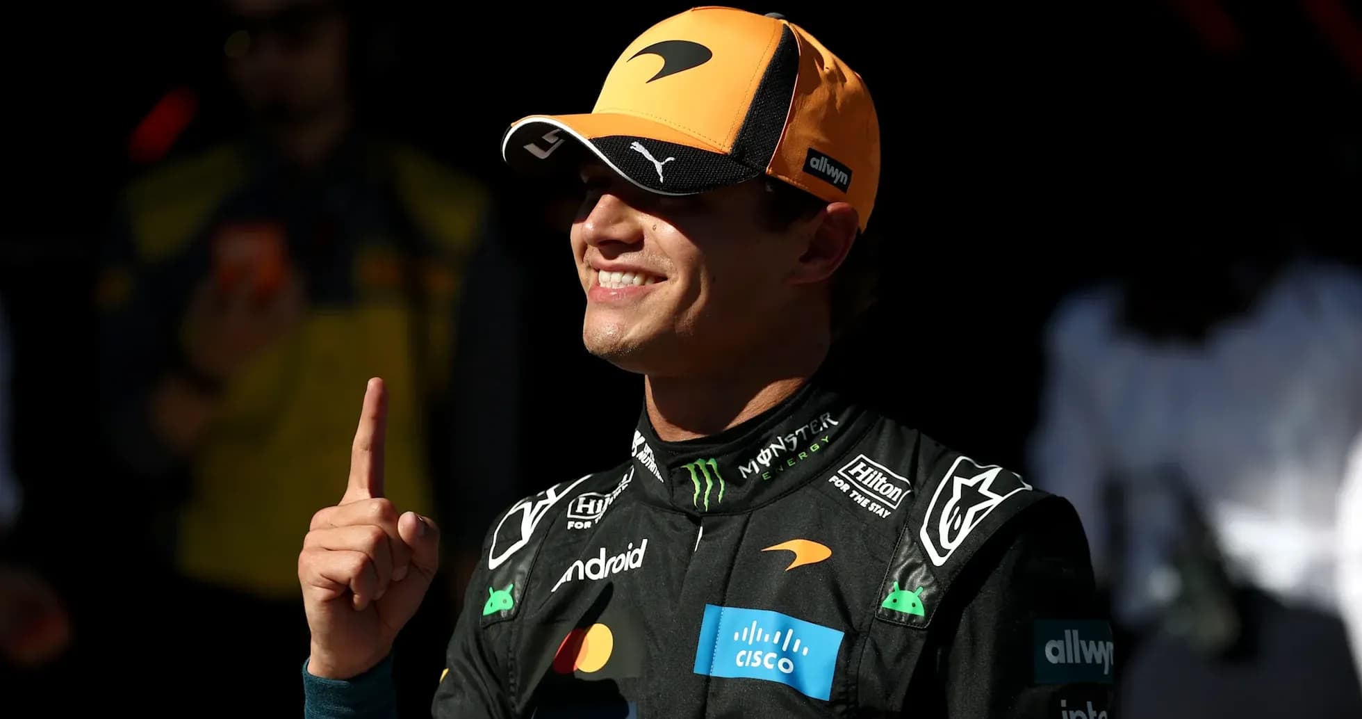 Driver celebrating with a finger raised in the air