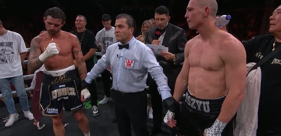 Boxers standing with referee after match announcement