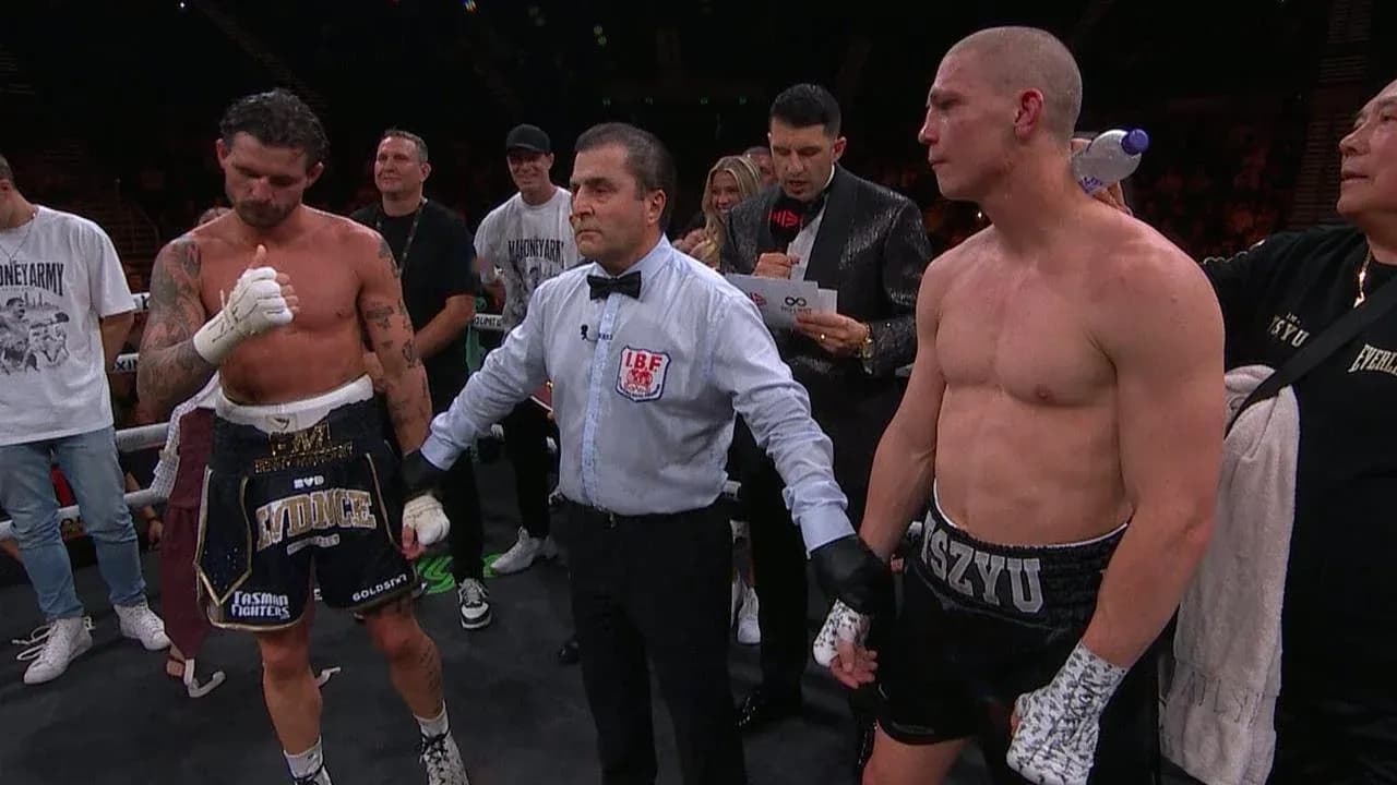 Boxers standing with referee after match announcement