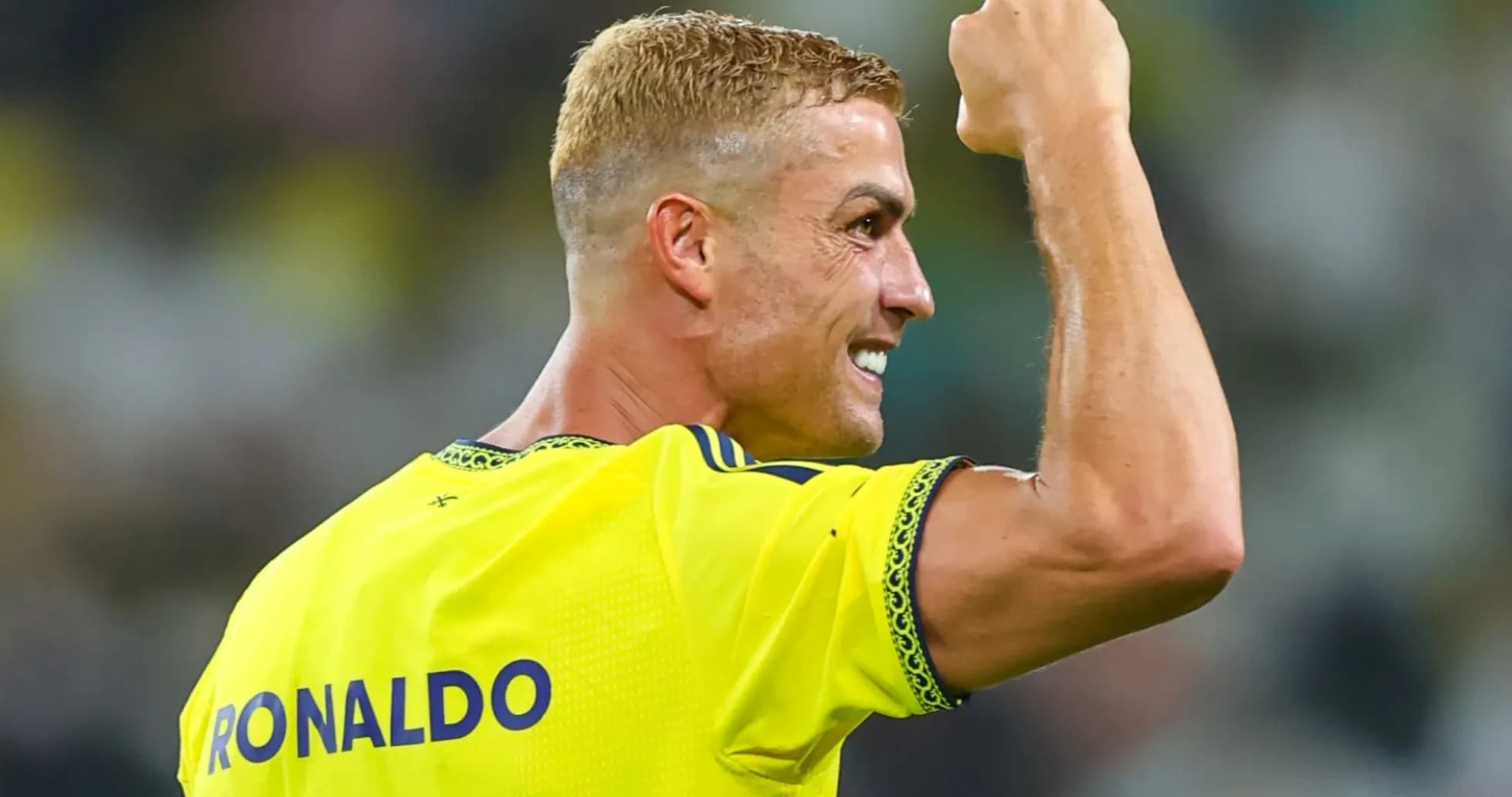 Player celebrating with raised fist in yellow jersey