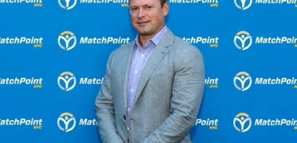 Man in suit posing against MatchPoint backdrop