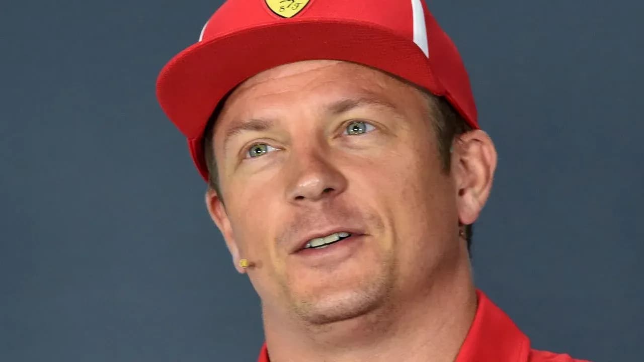 Driver speaking at press conference wearing red cap