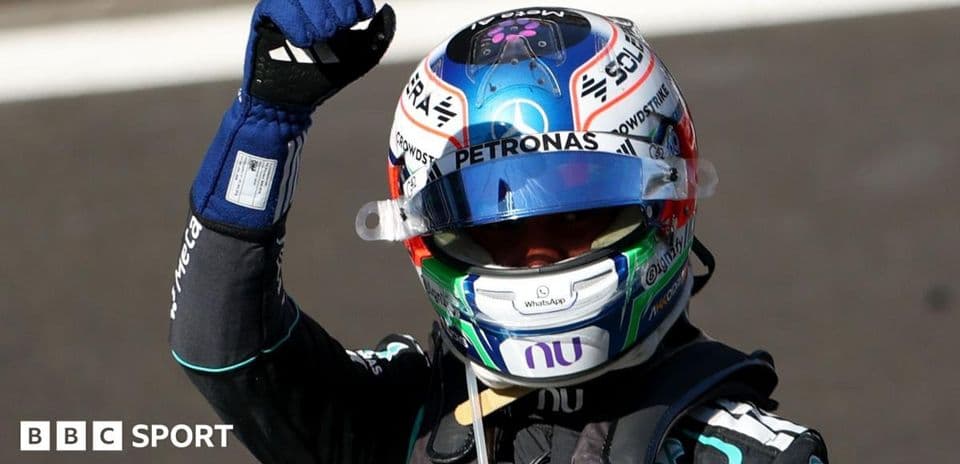 Racing driver celebrating with raised fist in helmet