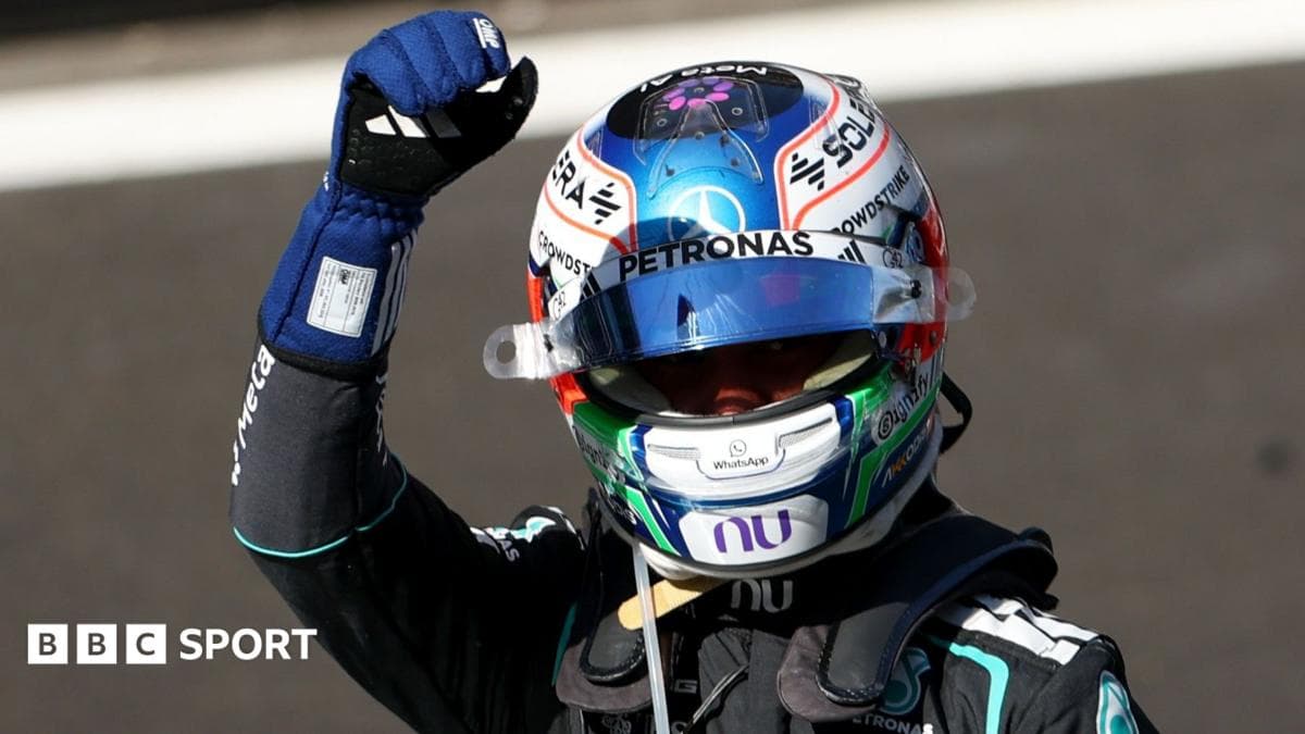 Racing driver celebrating with raised fist in helmet