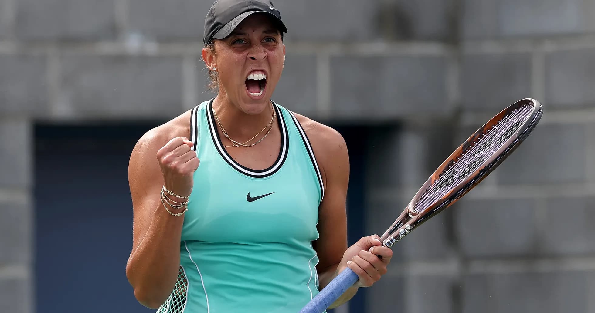Tennis player celebrating with racket after winning point