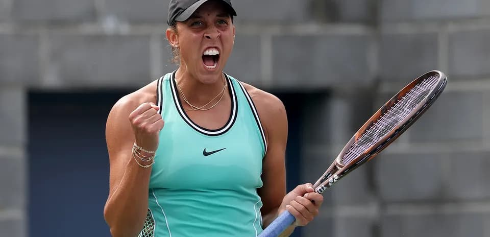 Tennis player celebrating with racket after winning point