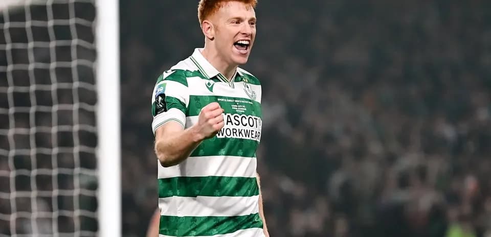 Player celebrating a goal in green and white kit