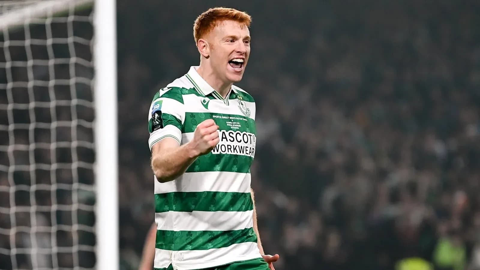 Player celebrating a goal in green and white kit