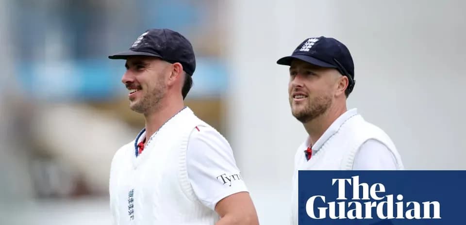 Two cricketers walking on the field in uniforms