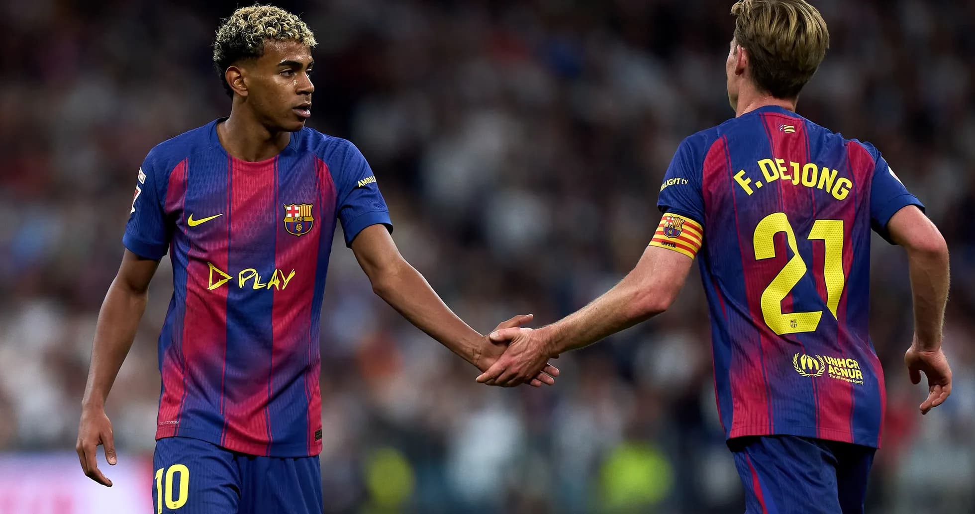 Two FC Barcelona players exchanging a handshake