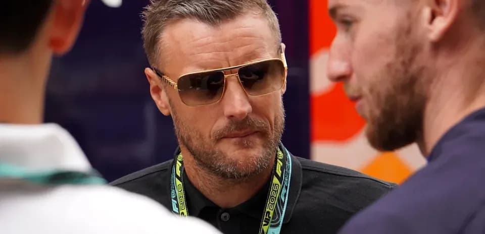 Man wearing sunglasses talking with two others