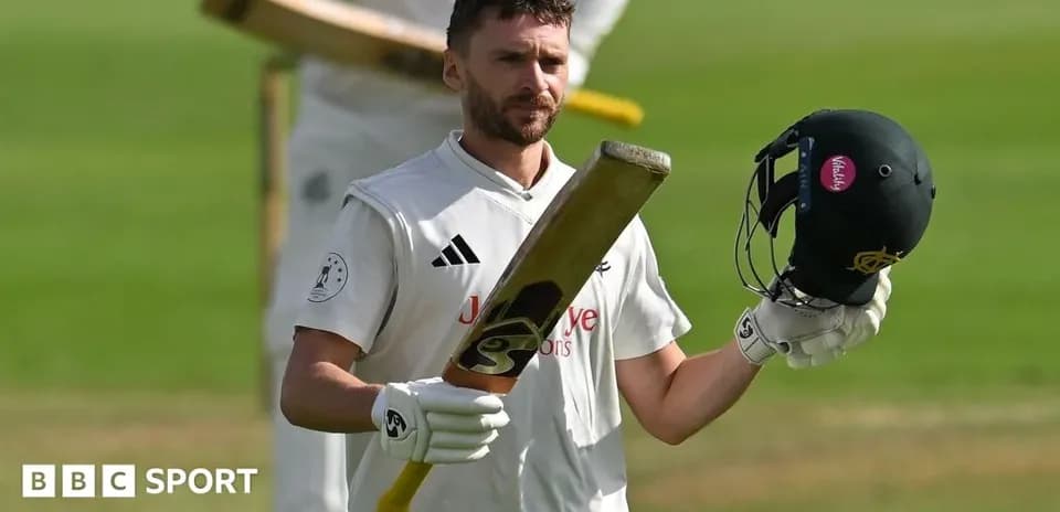 Batsman raising bat and helmet after scoring