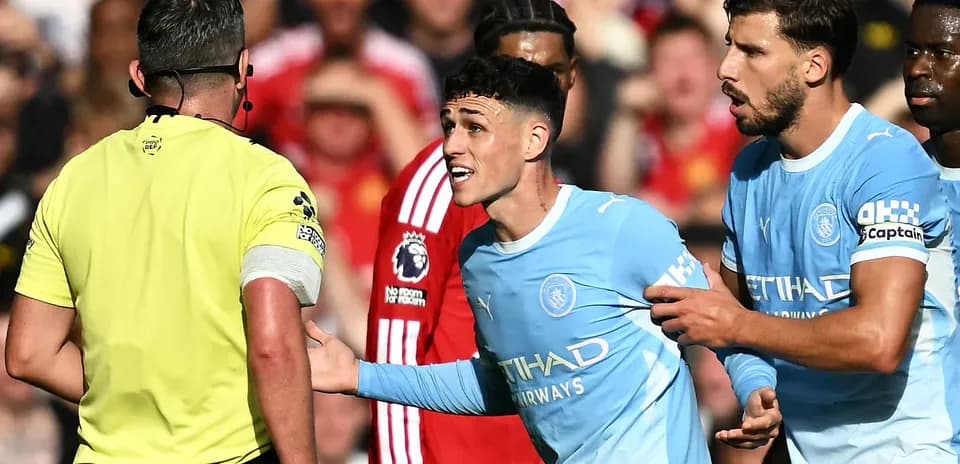 Manchester City players arguing with the referee