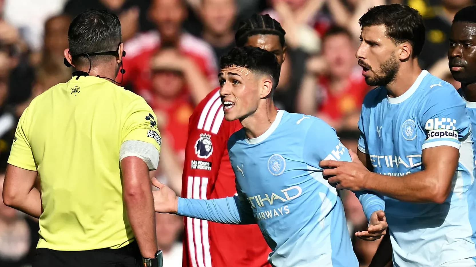 Manchester City players arguing with the referee