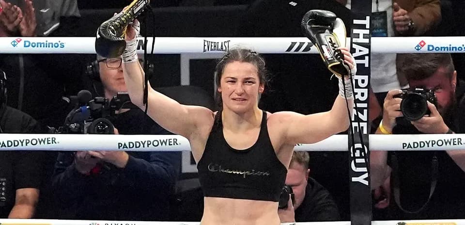 Female boxer celebrating victory with gloves raised