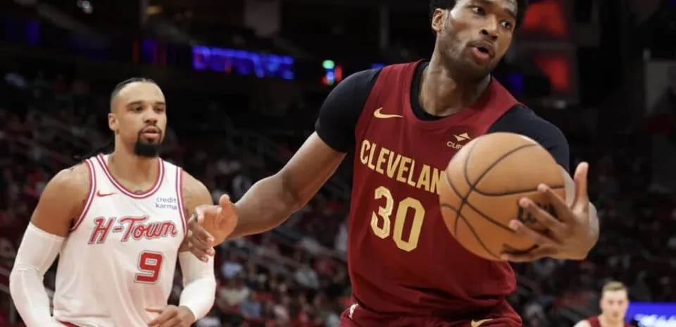 Cleveland player dribbling basketball against defender